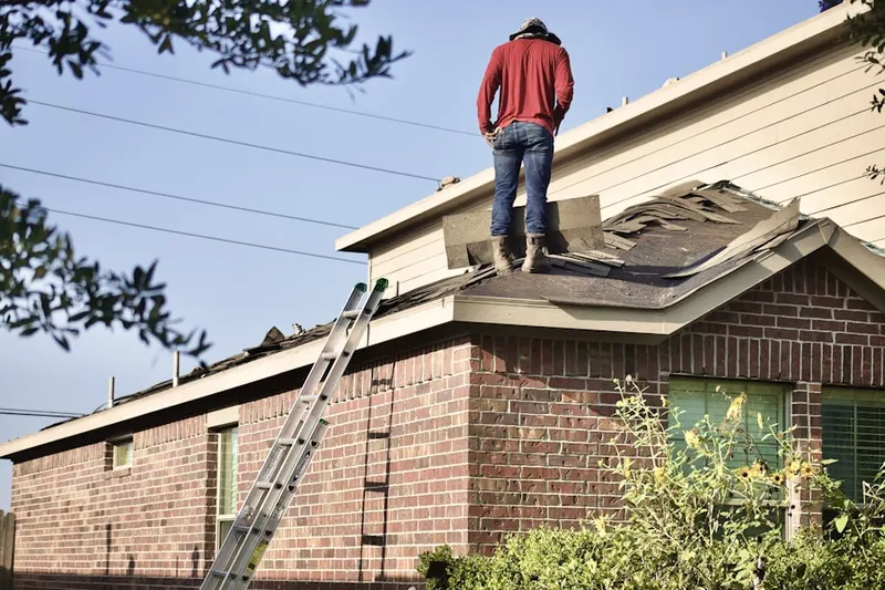 Professional roofer working on a residential roof in Andover Lakes